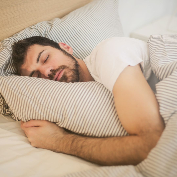 man sleeping on stripped bedding